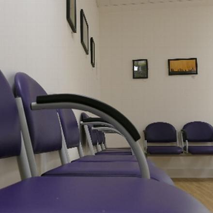 waiting area with purple chairs and framed artwork on the walls